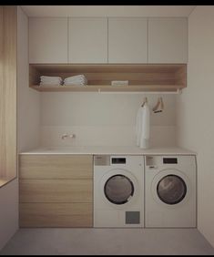 a washer and dryer in a small room with white cabinets on the wall