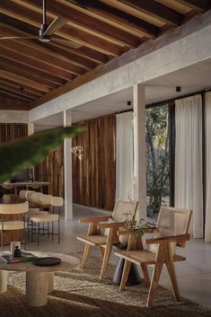 a living room filled with lots of furniture next to a wooden ceiling covered in windows