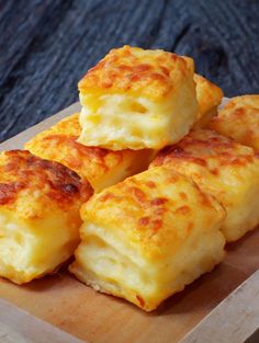 four cheesy biscuits on a cutting board ready to be eaten with cheese and sauce