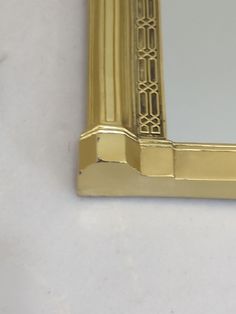 a gold framed mirror sitting on top of a white counter