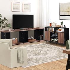 a living room filled with furniture and a flat screen tv on top of a wooden table