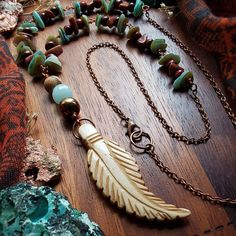 ● This lovely beaded bone necklace is made with an ethically-sourced carved bone feather pendant (carvings on both sides), a picture jasper stone bead, a hematite bead, a faceted teal jade stone bead, sandalwood beads, mother of pearl chip beads, goldstone beads, copper wire, antique copper jump rings, clasps, & chains.  ▪︎Listing includes ONE (1) necklace unless quantity is adjusted.  ▪︎NOTE▪︎ Each necklace is only partially beaded along the chain length.  ● PENDANT DIMENSIONS (Approximate): ▪︎Length: 2.5" ▪︎Width: 3/4" ■ All JSD orders include complimentary gift wrapping, along with a small gift as a token of my gratitude. * (Quantity: Though others may be recreated similarly upon request, custom made orders will require more time, depending on supply inventory, please contact me. :) ) Bohemian Bone Colored Jewelry For Festivals, Bohemian Bone-colored Necklace For Festivals, Bohemian Bone-colored Jewelry For Festival, Bone Color Bohemian Adjustable Necklace, Handmade Bohemian Bone Beaded Necklaces, Stretch Beaded Bracelets Diy, Ellijay Ga, Bone Necklace, Bone Jewelry