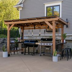 an outdoor kitchen with grill and seating area