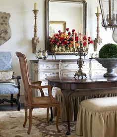 a dining room table with chairs and a mirror