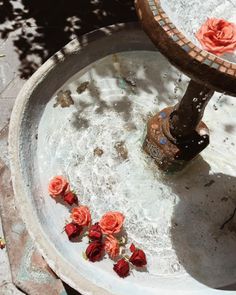 an outdoor fountain with flowers on the ground