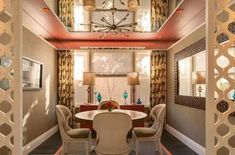 a dinning room table with four chairs and a chandelier hanging from the ceiling