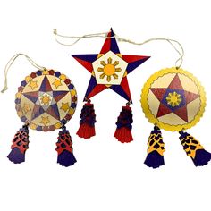 three decorative ornaments hanging from strings on a white background, each decorated with different colors and shapes