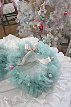 a wreath on top of a bed in front of a christmas tree