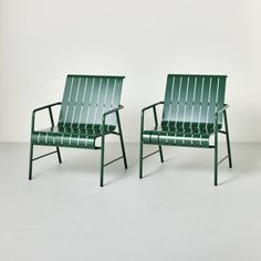 two green chairs sitting next to each other on top of a white floor covered ground