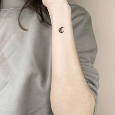 a woman with a small crescent tattoo on her arm