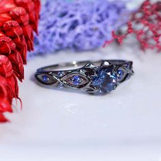 a close up of a ring on a table with red flowers and other items in the background