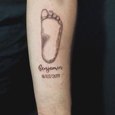 a person with a tattoo on their arm that has a foot print and the name benjam