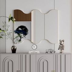 a white dresser with a mirror and vase on top of it next to a plant