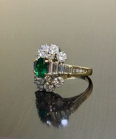 DeKara Designs Classic Handmade Art Deco Oval Emerald and Diamond Ring. Metal- 18K Yellow Gold, .750 Stones- 1 Oval Natural Green Colombian Emerald 0.81 carats, 22 Round Diamonds, 10 Baguette Diamonds, F-G Color VS2 Clarity 2.85 Carats. Art Deco inspired 18K Yellow Gold Diamond Colombian Emerald Engagement Ring. The ring features a beautiful green Colombian Emerald, that is truly an exceptional color and quality. There are five baguette diamonds on each side of the emerald that are prong set, an Luxury Gold Emerald Ring For Wedding, Luxury Oval Diamond Ring For Marriage, Classic Hallmarked Emerald Ring For Wedding, Luxury Multi-stone Wedding Rings, Yellow Gold Multi-stone Emerald Cut Diamond Ring, Luxury Hallmarked Emerald Wedding Ring, Elegant Multi-stone Diamond Wedding Ring, Art Deco Yellow Gold Emerald Ring With Brilliant Cut, Anniversary Yellow Gold Multi-stone Emerald Ring