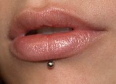 a woman's lip with a tiny piercing on the end of her tongue and nose