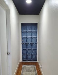 an empty hallway with a blue door and rug