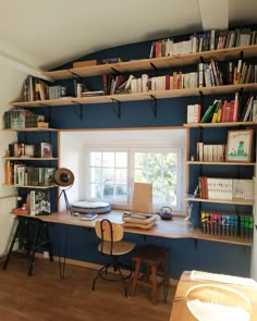 an office with bookshelves and desk in the corner