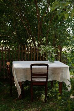 a table with a white cloth on it sitting in the grass