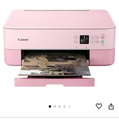 a pink printer is sitting on top of a white table and it's open