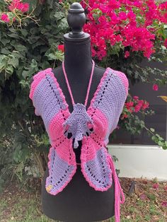 a purple and pink crocheted shawl on top of a mannequin