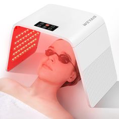 a woman with sun glasses laying down next to a heater that is on top of her head