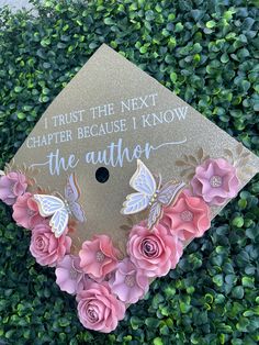 a graduation cap decorated with pink flowers and butterflies that says, i trust the next charter because i know the author