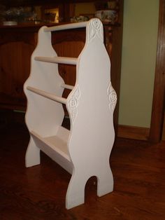 a white wooden bench sitting on top of a hard wood floor