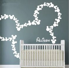 a baby's room with a crib and wall decal in the shape of mickey mouse