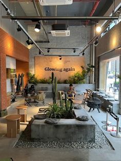 the inside of a building with people sitting at tables and chairs in front of it