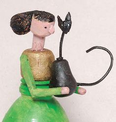 a small figurine sitting on top of a green vase