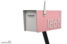 a pink and gray mailbox with the number 1565 on it's side