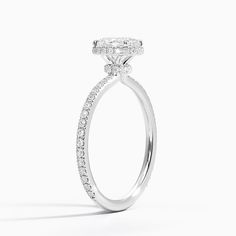 a white gold ring with diamonds on the sides and an oval shaped diamond in the center