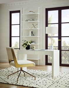 a white desk and chair in a room with wooden floors, windows, and rug