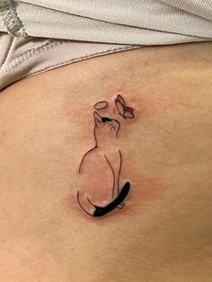 a woman's stomach with a small dog tattoo on the side of her belly