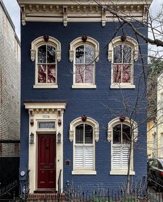 a blue house with red door and windows