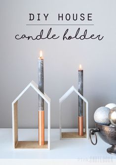 diy house candle holders with candles in them on a white table next to a silver bowl