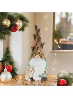 a figurine sitting on top of a table next to christmas decorations