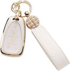 a white leather key chain with an embellishment on the front and back of it