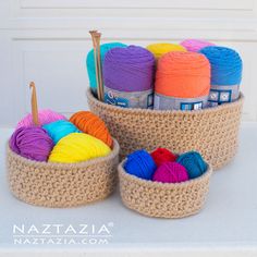 three baskets filled with balls of yarn and crochet hooks