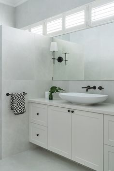 a bathroom with a sink, mirror and towel rack in it's center area