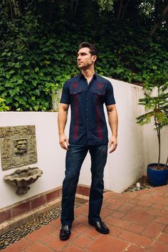 Measurements: Model is wearing size Medium. Fit: Relaxed Fit About: This stylish men's Guayabera shirt is perfect for staying cool in the heat. Made with breathable and lightweight material, the Guayabera shirt features traditional Aztec embroidery and four pocketed-details. With a relaxed camp collar and pintuck detailing, you'll look great and feel comfortable wherever you go. Details & Features: Breathable Fabric Pintuck Detailing Embroidered Aztec design Front button fastenings Short Sleeve Casual Traditional Fit Summer Tops, Casual Traditional Fit Shirt For Summer, Traditional Fit Short Sleeve Tops For Summer, Fitted Long Sleeve Camp Shirt Casual, Fitted Long Sleeve Casual Camp Shirt, Mens Guayabera Shirts, Aztec Embroidery, Guayabera Shirt, Aztec Design