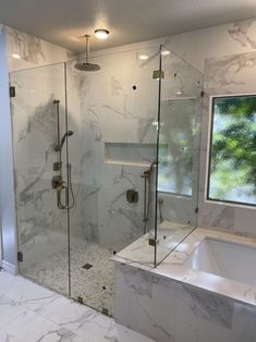 a bathroom with a walk in shower next to a bathtub