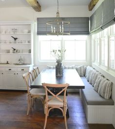 a dining room table and bench in front of a window