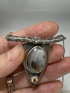 This pendant is nature-inspired. The Montana agate was pulled directly from the Yellowstone River in Montana. Nature-inspired Agate Jewelry For Gifts, Agate Large Pendant Necklace In Nature-inspired Style, Nature-inspired Agate Necklace With Large Pendant, Nature-inspired Oval Agate Jewelry, Nature-inspired Agate Round Pendant Necklaces, Nature-inspired Agate Round Pendant Necklace, Nature-inspired Oval Pendant Jewelry For Healing, Hand-forged Agate Pendant Necklace, Hand Forged Agate Pendant Necklace