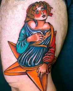 a tattoo on the leg of a man with an orange star and woman's face