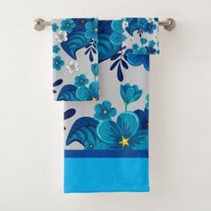 two blue and white towels hanging on a towel rack in front of a white wall