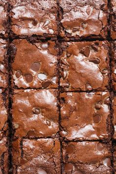 brownies with chocolate chips are arranged in rows on top of each other and have been cut into squares