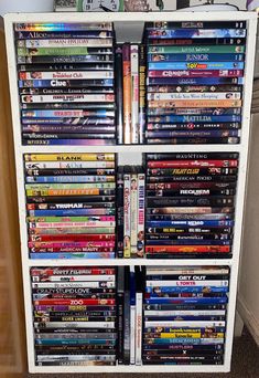 a white shelf filled with lots of movies