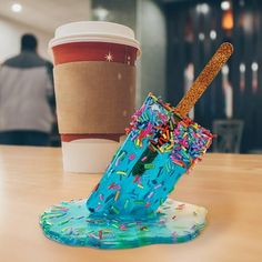 a cup with sprinkles and a straw sticking out of it on a table