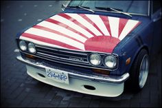 an old car painted in the colors of the american flag with sunbursts on it